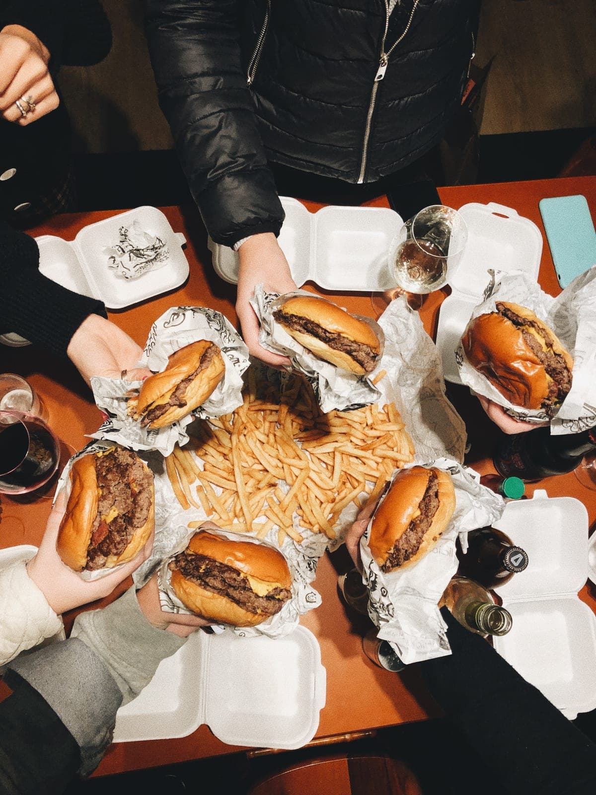 A late-night table, hands raising a shared meal