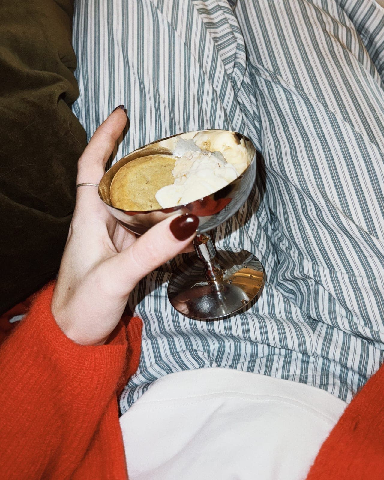 A coupe glass in a striped duvet